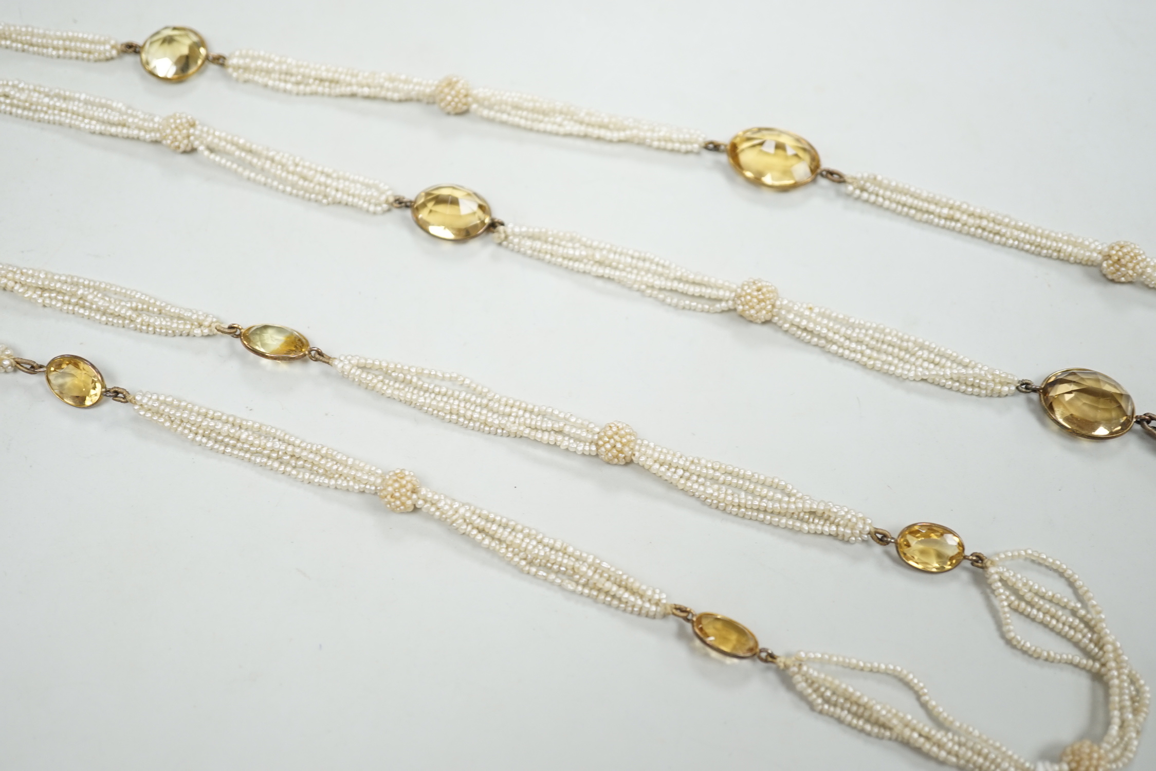A 19th century Indian multi strand seed pearl and oval cut citrine set long necklace, with gem set tassel drops, 166cm.